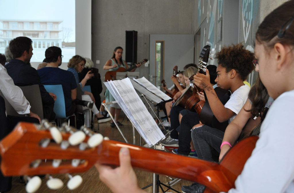 Die Gitarrengruppe von Andrea Klingler-Klapec spielt zur Einweihung des Kinderhauses an der Kirchhaldenschule auch die Titelmelodie von James Bond.