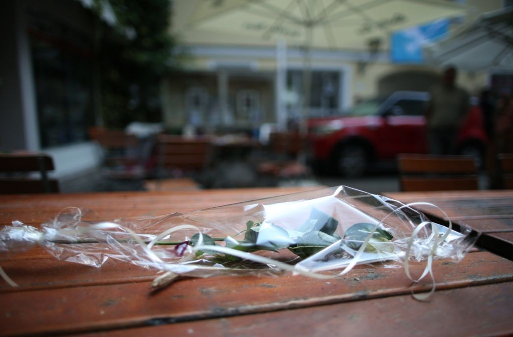 Eine weiße Rose liegt auf einem Tisch nahe des Tatortes in Ansbach.