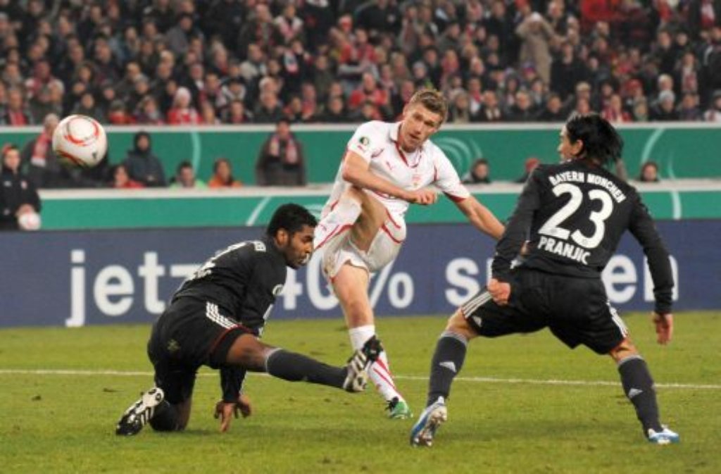 Fußball DFB-Pokal Achtelfinale: VfB Stuttgart - FC Bayern München am 22.12.2010 in der Mercedes-Benz Arena in Stuttgart. Pavel Pogrebnyak (Mitte) vom VfB Stuttgart schiesst, bedrängt von Breno (links) und Danijel Pranjic (rechts), das Tor zum 2:2 Ausgleich.
