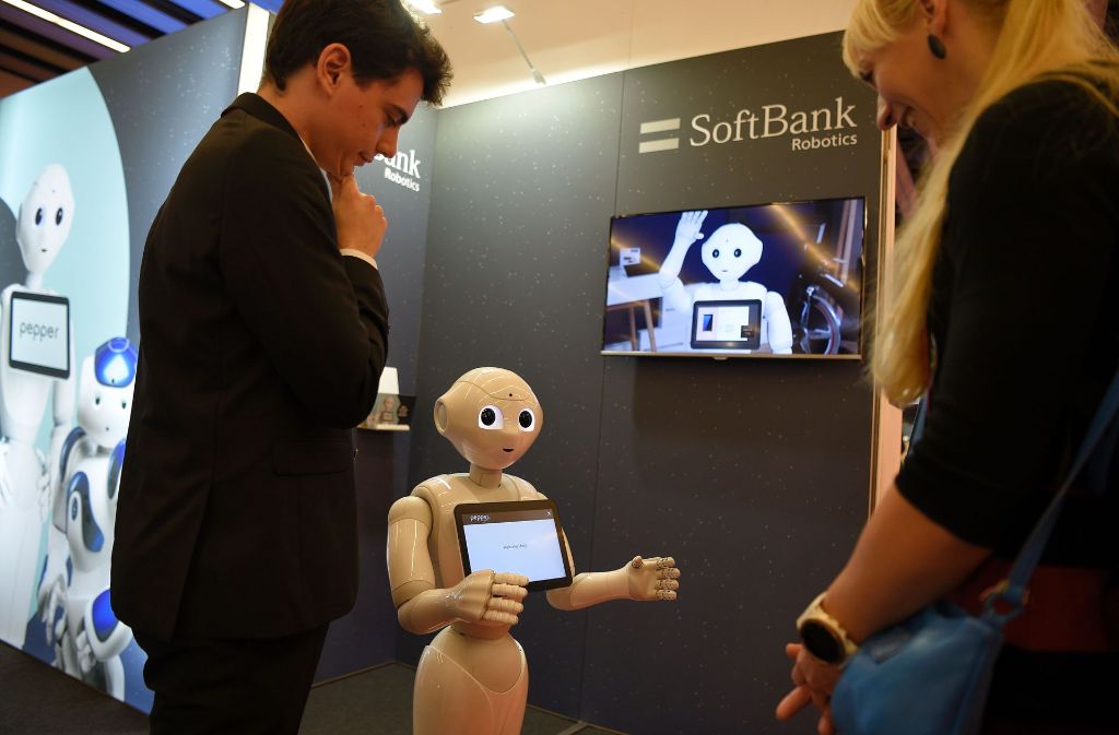 Ein Besucher bewundert den „Pepper“-Roboter am Stand von SoftBank Robotics.