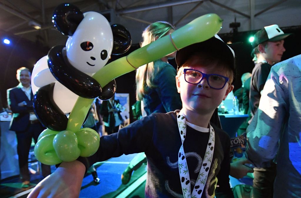 Auch dieser Junge weiß, was sich bei solchen „Staatsgästen“ gehört: Er feiert das Panda-Paar mit dem passenden Luftballon.
