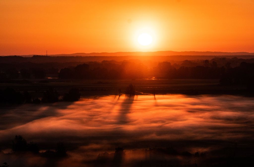 Die Sonne geht über einem mit Bodennebel verhängten Tal in Niederfinow in Brandeburg auf.