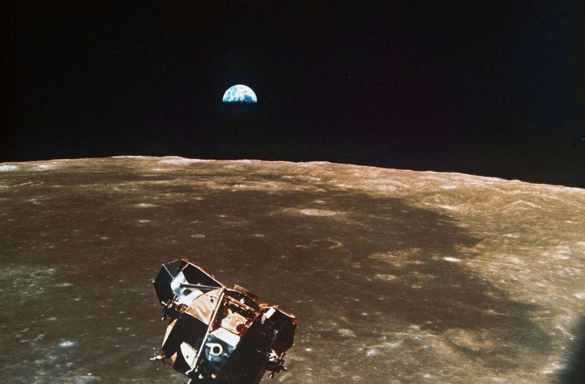 1969: Die Rückkehrstufe der Mondfähre mit den Astronauten Neil Armstrong und Edwin Aldrin an Bord schwebt über dem Mond kurz vor dem Ankoppeln an die Apollo-Kapsel. Im Hintergrund ist die Erde zu sehen.