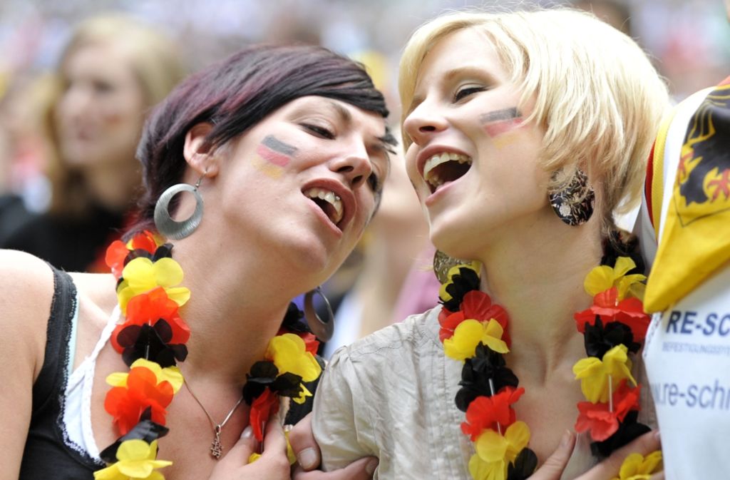 Fans der deutschen Fußball-Nationalmannschaft singen die deutsche Nationalhymne: Ist das schon Deutsch? oder was braucht, um als Deutscher Deutsch zu sein? Foto: dpa