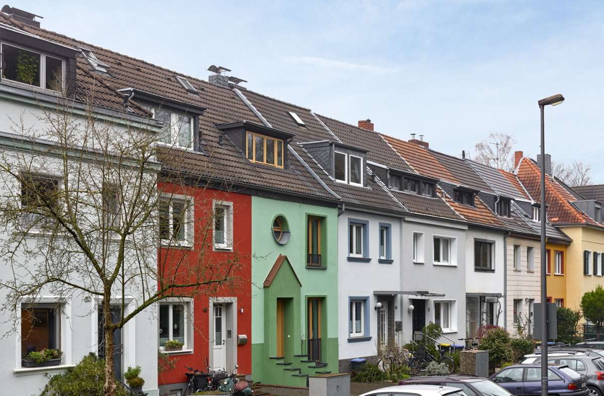 Das Haus im Kölner Stadtteil Zollstock tanzt nicht aus der Reihe, sondern sorgt gemeinsam mit einem ochsenblutrot gestrichenen Nachbarn für einen Farbakzent in der Reihenhaussiedlung.