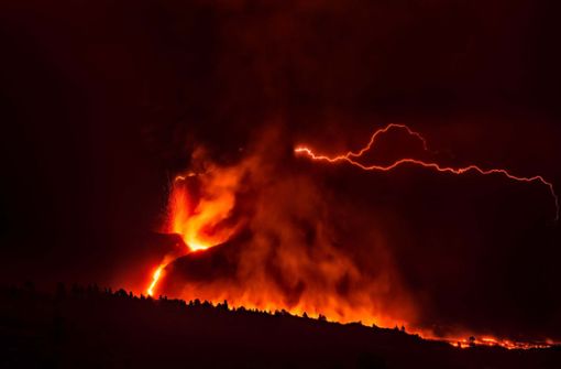 Ein vulkanischer Blitz über dem Vulkan Cumbre Vieja ist trotz des dichten, dunklen Rauchs, der aus dem Krater aufsteigt, von weitem sichtbar. Foto: dpa/Europa Press