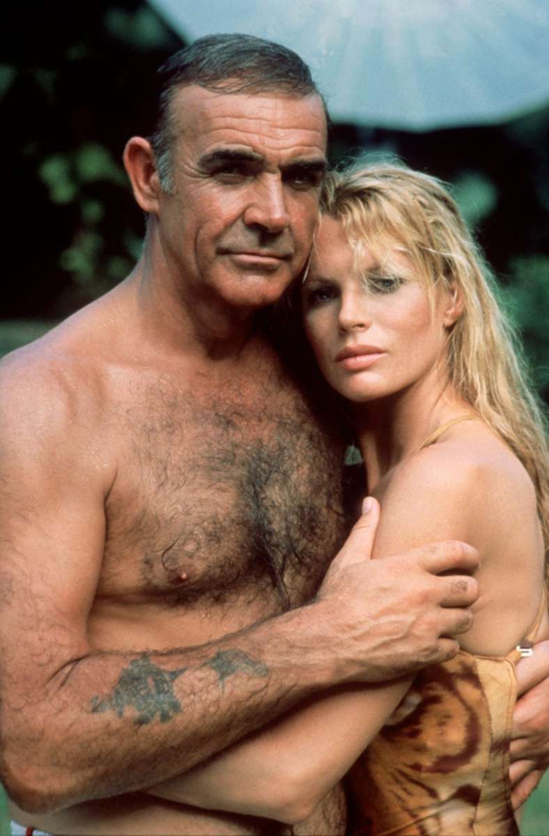 Der britische Schauspieler Sean Connery mit stark behaarter Brust als James Bond in einer Szene mit Kim Basinger in dem Film „Sag niemals nie“.