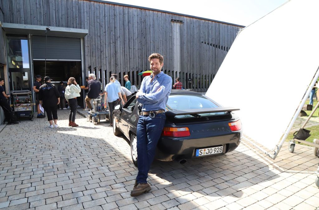 Soko-Stuttgart-Star Peter Ketnath lehnt sich in einer Drehpause in Rommelshausen an seinen Porsche 928. Foto: Patricia Sigerist