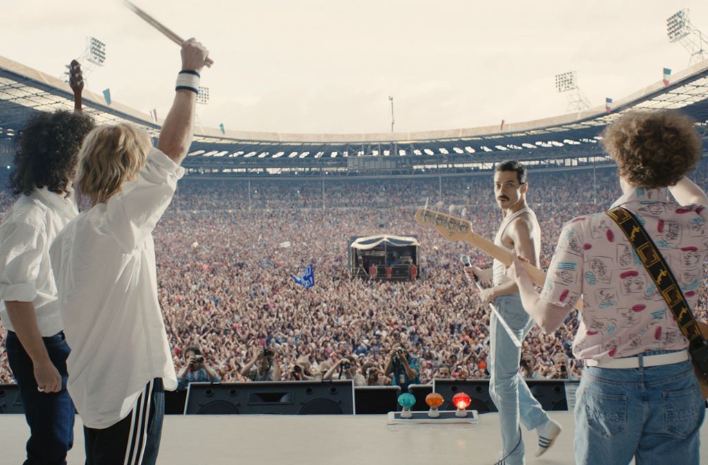 Rami Malek als Freddie Mercury mit der Band Queen vor nachinszenierter Live -Aid-Kulisse