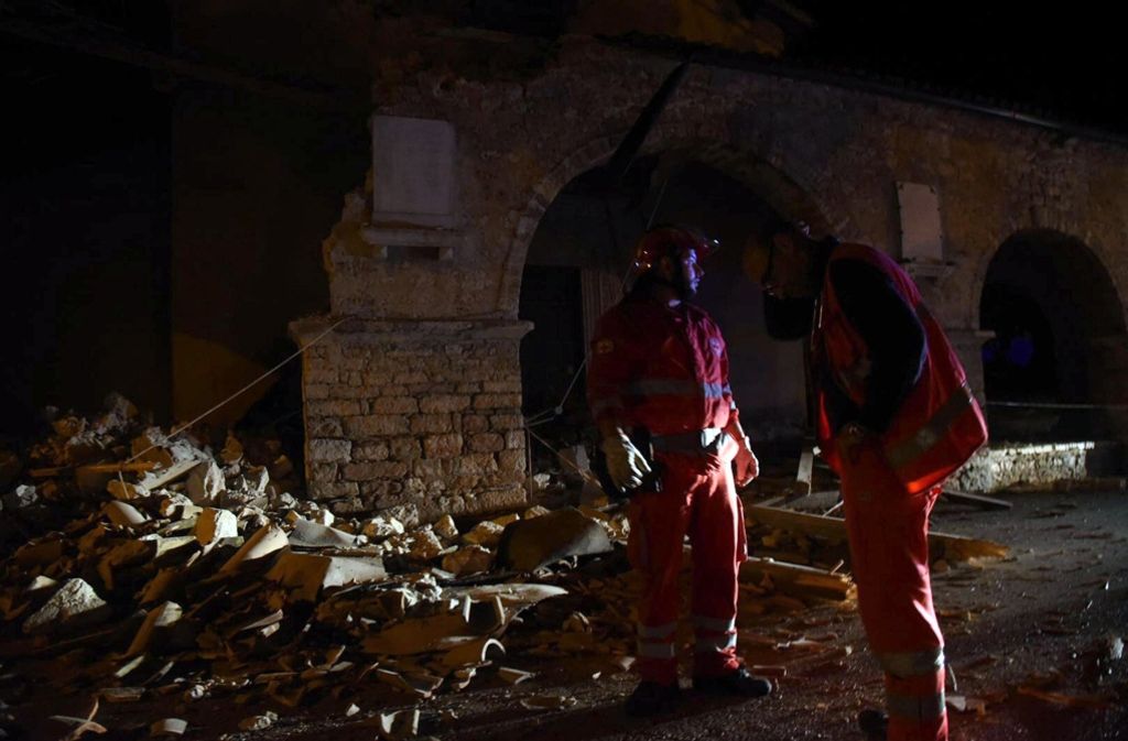 Rettungskräfte stehen in Visso in Italien vor den Trümmern.