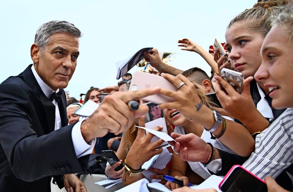 Wo er auftaucht, herrscht Hysterie: George Clooney verteilt am Lido Autogramme vor der Premiere seines Films „Suburbicon“ Foto: AFP/Filippo Monteforte