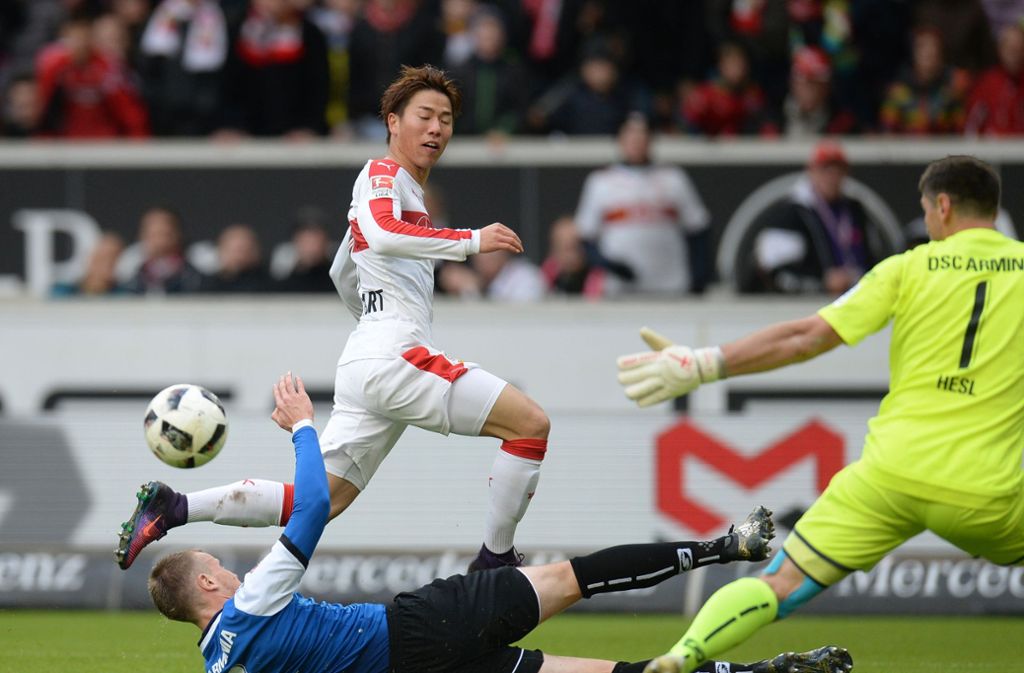 Stuttgarts Takuma Asano (oben) gegen Bielefelds Brian Behrendt und Torwart Wolfgang Hesl (rechts)