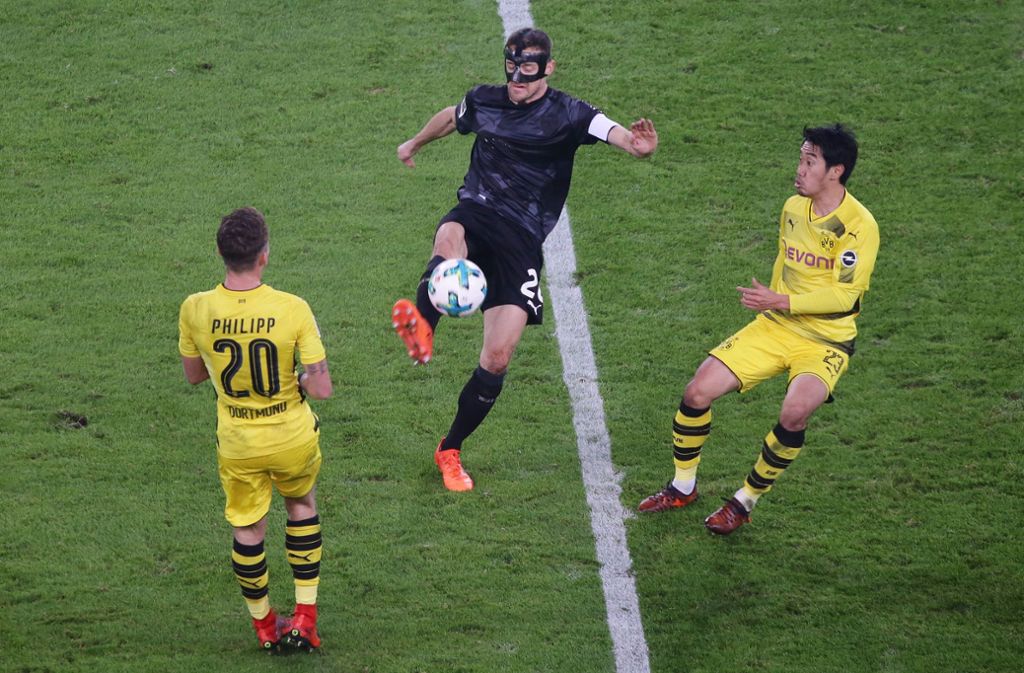 Zurück auf dem Feld ist der Maskenmann, der fortan eine Carbonmaske tragen muss, dann wieder im Spiel gegen Borussia Dortmund im November 2017. Der VfB gewinnt die Partie am Ende mit 2:1. Hier setzt sich Gentner (Mitte) gegen Maximilian Philipp (links) und Shinji Kagawa durch.