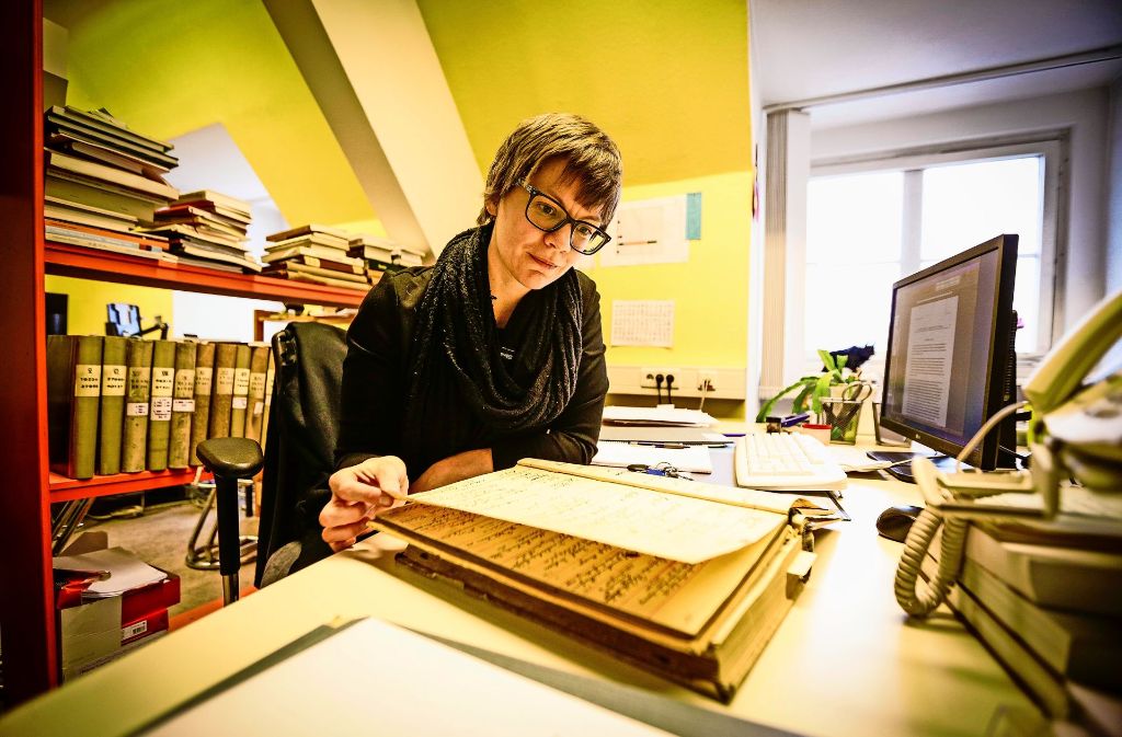 Gesa Grimme blättert in einem Inventarbuch des Lindenmuseums.