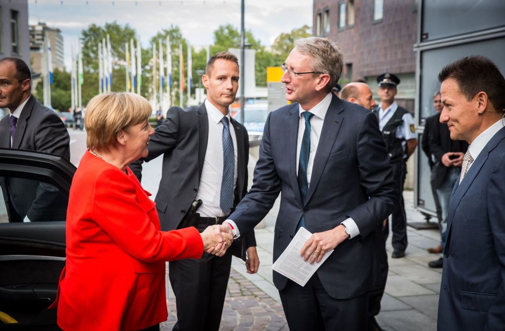 Pünktliche Ankunft: Die beiden Chefredakteure Joachim Dorfs (Stuttgarter Zeitung) und Christoph Reisinger (Stuttgarter Nachrichten/rechts) begrüßen Kanzlerin Angela Merkel vor der Liederhalle.