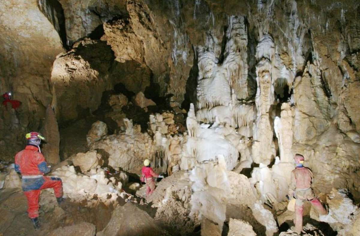 Vetterhöhle (Baden-Württemberg): Höhlenforscher stehen im Drachenfelsgang der Karsthöhle, die in der Nähe des Blautopfs bei Blaubeuren liegt.