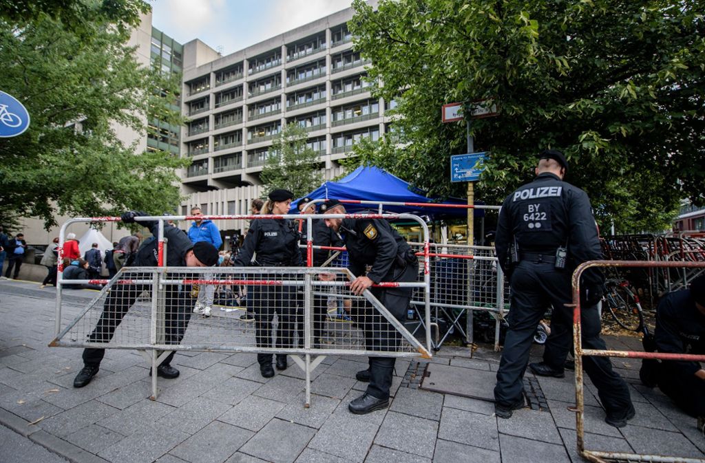 Polizisten stellen vor dem Oberlandesgericht in München Zäune auf.
