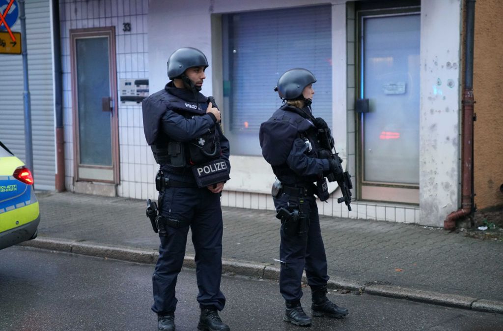 Zwei Beamte stehen in der Nähe des Tatorts. Fünf Männer sollen an einem Streit auf offener Straße beteiligt gewesen sein.