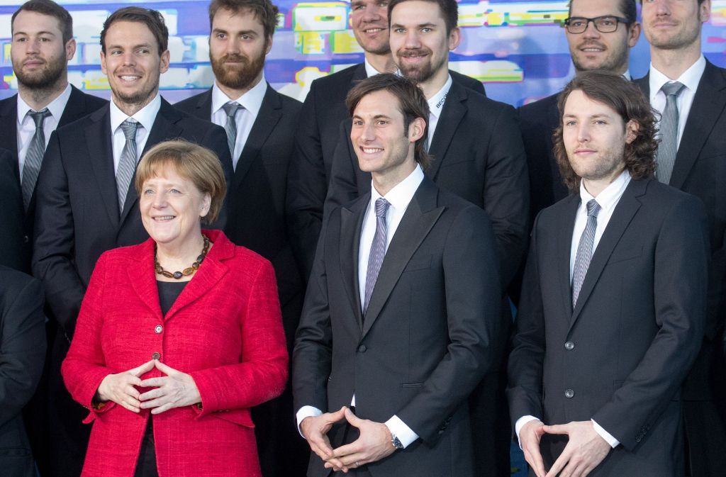 Bundeskanzlerin Angela Merkel empfängt die deutschen Handballer, weil sie nach wunderbaren Auftritten Europameister geworden sind und das deutsche Publikum verzückt haben. Und was machen die Lausbuben? Sie imitieren die Kanzlerin. Eigentlich geht das nicht – aber sie machen es sehr, sehr gut.